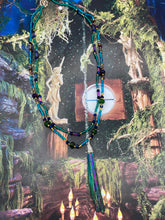 Load image into Gallery viewer, This Celestial and Galaxy Vibe Necklace features a 2 1/2" long Rainbow Kyanite Wired Stone pendant and two strands of multi-color glass beaded necklaces. The glass beads are an eclectic mix of sizes and shapes, including rectangular hematite beads, creating a shimmery, bold display of purples, blues, greens and golds. This necklace truly captures the essence of this celestial galaxy stone.Necklace is 15 1/2” in length can be adjusted to 18" in length