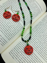 Load image into Gallery viewer, This 25mm bright orange pumpkin bead pendant necklace is a perfect complement to any Halloween ensemble. It is additionally enhanced by shimmery glass beads in classic Halloween hues, such as black, dark green, and light green. Measurements: Necklace is 19”