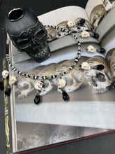 Load image into Gallery viewer, Black And White Vampire Goth Skulls Choker Style Necklace, Skully Witchy Vibe, Goth Dark Souls Jewelry, Day Of The Dead, Dia De Los Muertos, Howlite Skull Beads Black And Silver Glass BeadsThis statement necklace radiates a dark, shimmering aesthetic with two strands of glass beads connected through double-hole silver and black beads to create a collar shape. These dangling skulls beads are acompanied by black teardrop glass beads enable the piece to flow elegantly and express a bold, fierce look.