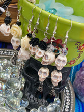 Load image into Gallery viewer, This luxurious design features two large howlite skull beads and a large black teardrop shaped glass bead; perfect for achieving a Chingona, Cabrona, Latina Chicana, Goth, Vampire Goth, Dark Witchy, La Bruja look. This statement jewelry will add a unique touch to any outfit.