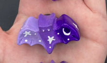 Load image into Gallery viewer, Cute and spooky magnet design to adorn your refrigerator, lockers, workstation, toolbox, or dishwasher. This hand-sculpted clay bat statuette boasts stunning ombre coloration, transitioning from dark purple to light purple to recreate the breathtaking look of a starry night sky. H 1” x W 2” x D 1/2”