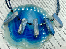 Load image into Gallery viewer, This sophisticated double-strand necklace glitters with silver and gray-tone glass beads, complemented by luminous blue crystal stone nuggets. It gracefully drapes around the neck. Measurements:  Necklace is 15 1/4”adjustable up to 17" in length