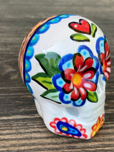 Load image into Gallery viewer, Inspired by nature, ceramic skull is full of vibrant colors and intricate details. The primary color is white with a black cat silhouette and multi-color floral motifs, along with hearts and leaves and lively colorful accents around the entire skull. Mini skull represented the eternal love for a special kitty cat in your life. Black cat silhouette is sitting on a tree branch admiring the starry night sky. Art created for all the cat lovers who adore their sweet kitty. Measurements: H 2 3/4” x W 2” x D 2”