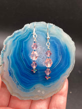 Load image into Gallery viewer, These dainty glass beaded earrings in soft pink and purple, featuring rainbow hematite beads, are perfect for summer ensembles and boho chic looks. An ideal accessory for nature lovers, these earrings will enhance any style.  Measurements: 1 1/2” in lengthThese dainty glass beaded earrings in soft pink and purple, featuring rainbow hematite beads, are perfect for summer ensembles and boho chic looks. An ideal accessory for nature lovers, these earrings will enhance any style.  Measurements: 1 1/2” in length