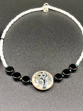 Load image into Gallery viewer, This impressive 24mm reconstituted quartzite lentil bead creates an eye-catching statement piece. The black and white glass beads add a sophisticated touch to its understated tree print. Perfectly suited to casual and formal occasions alike, this stunning necklace will complete any look. It was inspired by the stunning landscapes found in the U.S. National Arboretum in D.C. Measurements: Necklace is 17 " in length