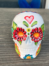 Load image into Gallery viewer, Inspired by nature, ceramic skull is full of vibrant colors and intricate details. The primary color is white with a black cat silhouette and multi-color floral motifs, along with hearts and leaves and lively colorful accents around the entire skull. Mini skull represented the eternal love for a special kitty cat in your life. Black cat silhouette is sitting on a tree branch admiring the starry night sky. Art created for all the cat lovers who adore their sweet kitty. Measurements: H 2 3/4” x W 2” x D 2”
