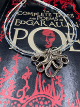 Load image into Gallery viewer, This stylish necklace features a silver plated metal octopus pendant and vibrant iridescent and silver-gray glass beads of various sizes. The Steampunk-inspired design provides a textured, patterned and voluminous look perfect for any dark goth or witchy aesthetic. Measurements: Necklace measures 15 1/2” adjustable up to 17” in length