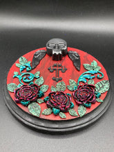 Load image into Gallery viewer, This Memento Mori Wall Art Decor is a one-of-a-kind art piece, skillfully crafted with a black polymer clay skull and wings on a dark red wood frame, decoratively woven with dark red roses and vines. It's perfect for adding an eye-catching touch to any wall and makes a unique, bold gift.  Measurements:  Diameter 6 3/4" x Depth 1 1/2"