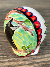 Load image into Gallery viewer, Inspired by nature, ceramic skull is full of vibrant colors and intricate details. The primary color is white with a black cat silhouette and multi-color floral motifs, along with hearts and leaves and lively colorful accents around the entire skull. Mini skull represented the eternal love for a special kitty cat in your life. Black cat silhouette is sitting on a tree branch admiring the starry night sky. Art created for all the cat lovers who adore their sweet kitty. Measurements: H 2 3/4” x W 2” x D 2”