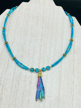 Load image into Gallery viewer, This Rainbow Kyanite Natural Wired Stone Choker Style Necklace presents two strands of light blue glass beads, and is adorned with a Kyanite stone known for its shimmering array of pink, gold, blue, and green hues. Providing a bold and attention-grabbing look, this piece of Hippie Crystal Jewelry is a must-have addition to any wardrobe. Necklace is 17 1/2” in length