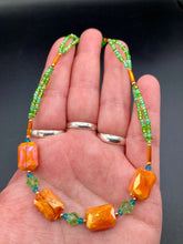 Load image into Gallery viewer, This unique, double-strand necklace consists of a blend of glass beads, including multi-green and rectangular, faceted orange glass beads, and is accented with gold and light blue elements. The vibrant combination is perfect for any summer look and will enhance any outfit.  Measurements:  Necklace is 16” and can be adjusted up to 18"