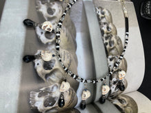 Load image into Gallery viewer, Black And White Vampire Goth Skulls Choker Style Necklace, Skully Witchy Vibe, Goth Dark Souls Jewelry, Day Of The Dead, Dia De Los Muertos, Howlite Skull Beads Black And Silver Glass BeadsThis statement necklace radiates a dark, shimmering aesthetic with two strands of glass beads connected through double-hole silver and black beads to create a collar shape. These dangling skulls beads are acompanied by black teardrop glass beads enable the piece to flow elegantly and express a bold, fierce look.