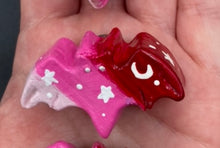 Load image into Gallery viewer, Cute and spooky magnet design to adorn your refrigerator, lockers, workstation, toolbox, or dishwasher. This hand-sculpted clay bat statuette boasts stunning ombre coloration, transitioning from dark red to light pink to recreate the breathtaking look of a starry night sky. H 1” x W 2” x D 1/2”