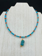 Load image into Gallery viewer, This adjustable choker style necklace features an eye-catching teal wood scarab beetle pendant and glass beaded strands. This dramatic necklace is kept together by double-hole flat matte lava-red beads, providing a collar shape. The necklace artfully wraps around the neck, conveying an elegant and bold style.  Measurements:    Necklace is 14 1/2” in length, can be adjusted up to 16"