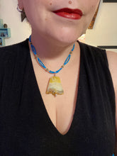 Load image into Gallery viewer, This two-strand necklace features an array of glass beads, including shades of green, blue and turquoise, as well as gold and green. Topped off with a show-stopping yellow agate stone in turquoise, the necklace boasts an eye-catching color combination. Measurements: Necklace is 15 1/2", adjustable up to 17”