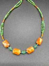 Load image into Gallery viewer, This unique, double-strand necklace consists of a blend of glass beads, including multi-green and rectangular, faceted orange glass beads, and is accented with gold and light blue elements. The vibrant combination is perfect for any summer look and will enhance any outfit.  Measurements:  Necklace is 16” and can be adjusted up to 18"