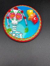 Load image into Gallery viewer, Transform your walls with this handcrafted polymer clay wall art. Showcasing a vibrant Frida Kahlo inspired calavera with hand-beaded floral crown, this Day of the Dead wall decor piece is perfect for adding a traditional Mexican folk art touch to any home.