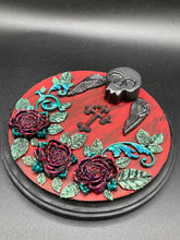 Load image into Gallery viewer, This Memento Mori Wall Art Decor is a one-of-a-kind art piece, skillfully crafted with a black polymer clay skull and wings on a dark red wood frame, decoratively woven with dark red roses and vines. It's perfect for adding an eye-catching touch to any wall and makes a unique, bold gift.  Measurements:  Diameter 6 3/4" x Depth 1 1/2"