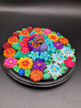 Load image into Gallery viewer, Frida Kahlo inspired calavera with a black wood frame, this Day of the Dead wall decor piece is perfect for adding a traditional Mexican folk art touch to any home. Add a unique touch of style to your home with this intricately detailed, Frida Kahlo-inspired calavera clay wall art. The design features an eye-catching crown of flowers, plus a vibrant bouquet, perfect for any Day of the Dead celebration. Bring a bright and colorful piece of art to your home with this stunning wall hanging.