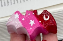 Load image into Gallery viewer, Cute and spooky magnet design to adorn your refrigerator, lockers, workstation, toolbox, or dishwasher. This hand-sculpted clay bat statuette boasts stunning ombre coloration, transitioning from dark red to light pink to recreate the breathtaking look of a starry night sky. H 1” x W 2” x D 1/2”