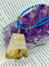 Load image into Gallery viewer, This two-strand necklace features an array of glass beads, including shades of green, blue and turquoise, as well as gold and green. Topped off with a show-stopping yellow agate stone in turquoise, the necklace boasts an eye-catching color combination. Measurements: Necklace is 15 1/2", adjustable up to 17”