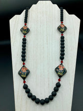 Load image into Gallery viewer, This statement necklace features elegant black matte glass beads with a smooth and velvety finish. Four ornamental ceramic beads with a traditional red, golden, and green pattern create a classic aura and luster-speckled dark red beads bring a striking final touch to the singular look.  This necklace is simple and elegant piece, very versatile look. Perfect cocktail chic attire, fancy wedding necklace, a minimalist look. Necklace: 32” in length