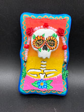 Load image into Gallery viewer, Transform your walls with this handcrafted polymer clay wall art. Showcasing a vibrant Frida Kahlo inspired calavera with hand-beaded floral crown, this Day of the Dead wall decor piece is perfect for adding a traditional Mexican folk art touch to any home.