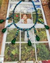 Load image into Gallery viewer, This Victorian-style necklace features a combination of green and blue glass beads, and rectangular, rainbow hematite beads for a layered and textured effect. The dramatic dark-green glass tear drops dangling from the strands provide additional depth and sophistication. Double-hole flat matte blue beads are used to hold the two strands together, creating a collar-like shape that softly cascades over your neckline. It is a striking, bold and elegant accessory.