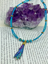 Load image into Gallery viewer, This Rainbow Kyanite Natural Wired Stone Choker Style Necklace presents two strands of light blue glass beads, and is adorned with a Kyanite stone known for its shimmering array of pink, gold, blue, and green hues. Providing a bold and attention-grabbing look, this piece of Hippie Crystal Jewelry is a must-have addition to any wardrobe. Necklace is 17 1/2” in length