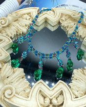 Load image into Gallery viewer, This Victorian-style necklace features a combination of green and blue glass beads, and rectangular, rainbow hematite beads for a layered and textured effect. The dramatic dark-green glass tear drops dangling from the strands provide additional depth and sophistication. Double-hole flat matte blue beads are used to hold the two strands together, creating a collar-like shape that softly cascades over your neckline. It is a striking, bold and elegant accessory.