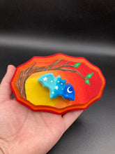 Load image into Gallery viewer, Starry Night Mini Bat Wall Art Decor. A perfect hanging art piece to add a pop of color to your wall, next to your display of crystals or witchy altar. Bat figurine is made of polymer clay, painted ombre colors from light to dark with white stars and crescent moon flying over the sun rise sky. Orange and red wood frame matches the light yellow, orange and red sky. Art come ready to hang with a sawtooth hangers on back. Measurements: H 3" x W 5” x D 1 1/2"