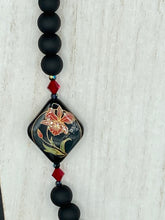 Load image into Gallery viewer, This statement necklace features elegant black matte glass beads with a smooth and velvety finish. Four ornamental ceramic beads with a traditional red, golden, and green pattern create a classic aura and luster-speckled dark red beads bring a striking final touch to the singular look.  This necklace is simple and elegant piece, very versatile look. Perfect cocktail chic attire, fancy wedding necklace, a minimalist look. Necklace: 32” in length