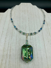 Load image into Gallery viewer, This gorgeous, Bohemian-style necklace features a shimmery aqua blue and gold-toned glass beaded design, with a large, faceted rectangular pendant adding dramatic flair. The vibrant and eye-catching colors make it the perfect way to add a pop of color to any ensemble and the draping style will give you a look that is both bold and elegant. Measurements: Necklace is 17” - adjustable to 18", pendant is 2 1/4”