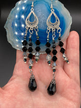 Load image into Gallery viewer, This stylish three-strand black and silver glass beaded earring design presents a beautiful dancing effect, boasting a large black teardrop glass bead. A versatile accessory, it suits a variety of ensembles from cocktail chic to wedding fineries, and its minimalist aesthetic lends a modern charm.  Measurements: 3 3/4” in length