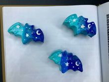 Load image into Gallery viewer, Cute and spooky magnet design to adorn your refrigerator, lockers, workstation, toolbox, or dishwasher. This hand-sculpted clay bat statuette boasts stunning ombre coloration, transitioning from dark blue to light blue to recreate the breathtaking look of a starry night sky. H 1” x W 2” x D 1/2”