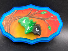 Load image into Gallery viewer, This unique Starry Night Mini Bat Wall Art Decor is hand sculpted and painted in vivid hues to offer an eye-catching decoration for your living space. The bat is painted in a gradient of light green to dark green to black, and is complemented by white stars and a crescent moon. The wood frame is painted in yellow, orange and red for a stunning sundown effect, with a royal blue edge for added contrast.