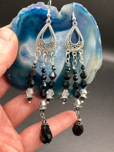 Load image into Gallery viewer, This stylish three-strand black and silver glass beaded earring design presents a beautiful dancing effect, boasting a large black teardrop glass bead. A versatile accessory, it suits a variety of ensembles from cocktail chic to wedding fineries, and its minimalist aesthetic lends a modern charm.  Measurements: 3 3/4” in length