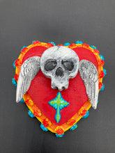 Load image into Gallery viewer, This Memento Mori Wall Art Decor is a unique statement piece to add a pop of color to your walls. Handcrafted with black and white polymer clay, acrylic paint, and a wood frame, the skull artwork is decorated with small turquoise and yellow-orange flowers and a turquoise and gold cross. Perfect for a Day of the Dead altar or a witchy home decor display.