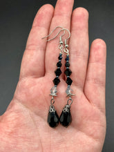 Load image into Gallery viewer, These shimmering black and silver glass beaded earrings feature a large black teardrop glass bead for added movement. This sophisticated and versatile accessory can be worn for an elegant evening look, brunch ensemble, wedding necklace, or minimalist style.  Measurements: 2 1/2” in length