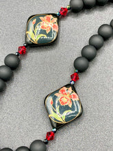 Load image into Gallery viewer, This statement necklace features elegant black matte glass beads with a smooth and velvety finish. Four ornamental ceramic beads with a traditional red, golden, and green pattern create a classic aura and luster-speckled dark red beads bring a striking final touch to the singular look.  This necklace is simple and elegant piece, very versatile look. Perfect cocktail chic attire, fancy wedding necklace, a minimalist look. Necklace: 32” in length Necklace: 32” in length