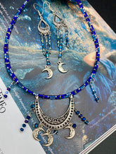 Load image into Gallery viewer, These three-strand chandelier style earrings offer an ornate and eye-catching look with their whimsical blue celestial charm accents adorned with smiling crescent moon designs. Perfect for creating a fairy princess, witchy, or boho aesthetic, they provide plenty of movement and can easily be added to any jewelry collection.  Measurements: 3 1/2” in length