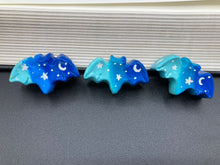 Load image into Gallery viewer, Cute and spooky magnet design to adorn your refrigerator, lockers, workstation, toolbox, or dishwasher. This hand-sculpted clay bat statuette boasts stunning ombre coloration, transitioning from dark blue to light blue to recreate the breathtaking look of a starry night sky. H 1” x W 2” x D 1/2”