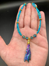 Load image into Gallery viewer, This Rainbow Kyanite Natural Wired Stone Choker Style Necklace presents two strands of light blue glass beads, and is adorned with a Kyanite stone known for its shimmering array of pink, gold, blue, and green hues. Providing a bold and attention-grabbing look, this piece of Hippie Crystal Jewelry is a must-have addition to any wardrobe. Necklace is 17 1/2” in length