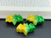 Load image into Gallery viewer, Cute and spooky magnet design to adorn your refrigerator, lockers, workstation, toolbox, or dishwasher. This hand-sculpted clay bat statuette boasts stunning ombre coloration, transitioning from to dark green to light green and then to bright yellow to recreate the breathtaking look of a starry night sky. H 1” x W 2” x D 1/2”