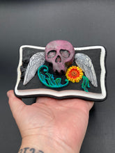 Load image into Gallery viewer, This unique wall art decor, crafted with hand-molded polymere clay and painted on a wooden frame, brings to life a classic Dia De Los Muertos Calavera with its fiery-red skull and bright yellow-orange flower and vine accents. Perfect for accenting your crystal display, witchy altar, or indoor garden.