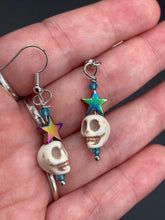 Load image into Gallery viewer, Mini Howlite Skull Bead Earrings, star shaped rainbow hematite beads for a fun pastel goth vibe. Perfect for pastel goth, dark witchy, celestial galaxy stardust, day of the dead jewelry. You can dress these up or down, it will definitely give your outfit a unique look. Measurements: 1 1/2 ” in length