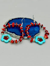 Load image into Gallery viewer, These Bamboo coral red stone chip earrings feature a subtle hoop design adorned with tiny turquoise, red, and gold glass beads. Completing the look is a turquoise flower pendant with a dark red glass bead in the center. Measurements: 2" length