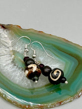 Load image into Gallery viewer, Mismatched round bone beads create an adaptable look when paired with neutral colors and wavy patterns, enabling wearers to tailor their ensembles in whatever way they desire. Measurements: 1 1/2 ” in length