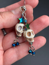 Load image into Gallery viewer, Mini Howlite Skull Bead Earrings, Stardust Galaxy Cosmos large star shaped rainbow hematite beads and light blue glass bead for a pastel goth vibe. Two small dark blue glass beads on the bottom to add some movement. Perfect for a witch, goth, or day of the dead outfit. You can dress these up or down, it will definitely give your outfit a unique look. Measurements: 2 ” in length