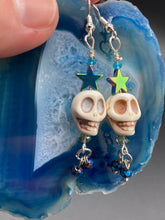 Load image into Gallery viewer, Mini Howlite Skull Bead Earrings, Stardust Galaxy Cosmos large star shaped rainbow hematite beads and light blue glass bead for a pastel goth vibe. Two small dark blue glass beads on the bottom to add some movement. Perfect for a witch, goth, or day of the dead outfit. You can dress these up or down, it will definitely give your outfit a unique look. Measurements: 2 ” in length